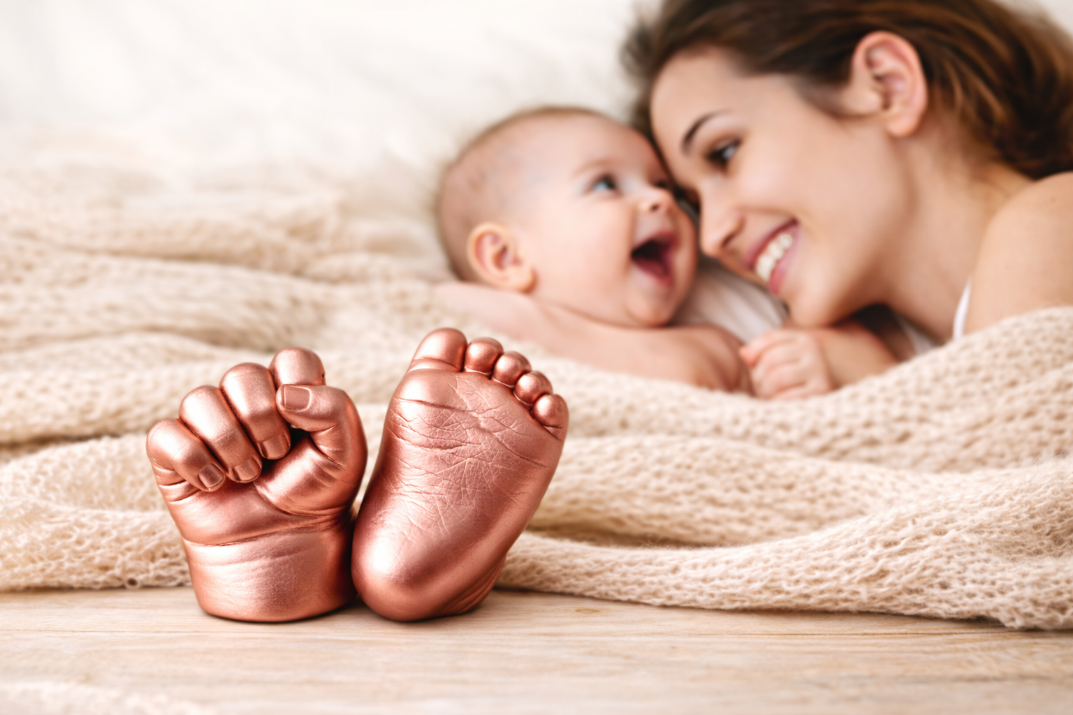 Mère et son bébé avec des moulages des mains et des pieds du bébé en plâtre de haute qualité